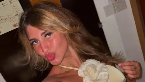 Bella Culley tells court she was tortured into smuggling drugs Bella Culley A selfie taken by Bella Culley. She is wearing a yellow dress with a fabric white flower at her neck. She is pouting at the camera and holding a strand of hair in her hand.