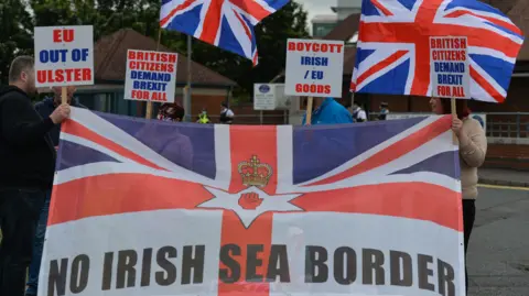 Julian Smith says David Cameron was 'cavalier' in handling of Brexit Getty Images People protesting with signs that say, no Irish sea border and EU out of Ulster. They are holding the Union flag and the red hand of Ulster with a crown over it is on one of the signs.