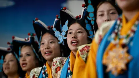 Thousands turn out to celebrate Dalai Lama's 90th birthday Reuters Tibetan girls in traditional attire including large pointed navy hats with sky blue adornments perform during birthday celebrations
