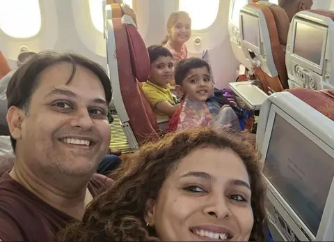 Victim's relative 'can't be at peace' until root cause known Supplied A middle-aged man sits next to his wife, who has long brown hair in one row of a plane. Across the aisle from the couple are their three children, two young boys and one young girl. They're all smiling.