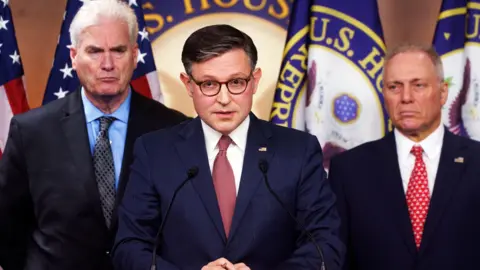 US House speaker shuts down chamber to block Epstein vote EPA Mike Johnson wears a blue suit with a stern expression standing at a podium