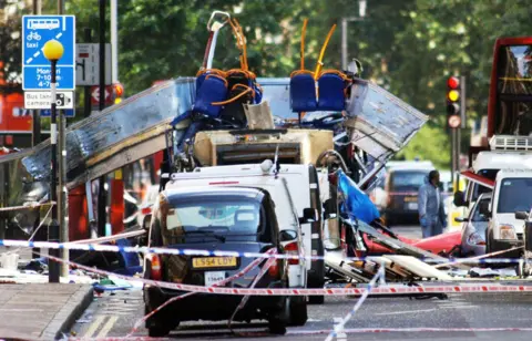 Olympics joy turned into a barbaric loss of life Fiona Hanson/PA A bus with its roof blown off is on a road.