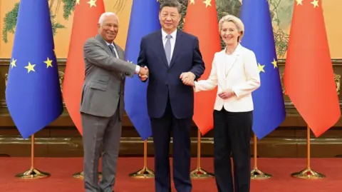 Reuters Chinese President Xi Jinping (centre) shakes hands with European Council President Antonio Costa and European Commission President Ursula von der Leyen at the Great Hall of the People in Beijing on 24 July, 2025. Behind them is a row of EU and China flags.