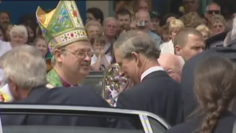 Police investigate sex abuse claims against men linked to Church Former Bishop of Swansea and Brecon Anthony Pierce wearing his robes and a hat meets the then Prince Charles, wearing a suit and white shirt, in a crowded street in Swansea