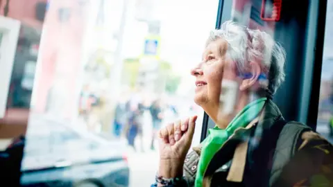 What is the triple lock and how much is the state pension worth? Getty Images An older woman smiles as she looks out of a bus window. She has short grey hair and is wearing a green scarf.