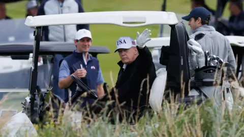 Security tightens as Donald Trump plays golf at Turnberry PA Media Donald Trump waves to onlookers from his golf buggy
