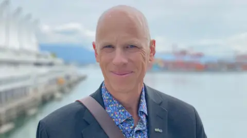 Trucking's uneasy relationship with new tech Eric Beckwitt in a blue jacket and blue, patterned shirt