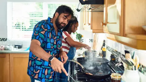 Household energy bills fall but may not go much lower Getty Images Couple cook on a hob in a kitchen.