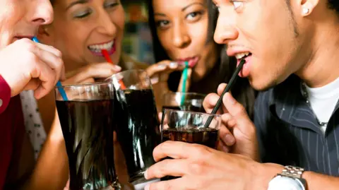 The big winner from Coca-Cola's Trump-inspired sugar push Getty Images Four friends drinking soda in a bar with colorful straws