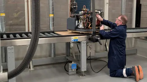 Manufacturers ready for more demand Chris Baraniuk A man kneeling works on an Octopus heat pump