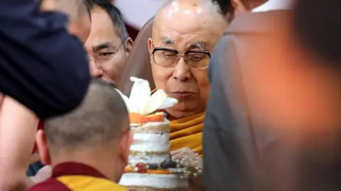 Thousands turn out to celebrate Dalai Lama's 90th birthday EPA/Shutterstock The bespectacled Dalai Lama cuts an iced white cake surrounded by people during his 90th birthday celebrations