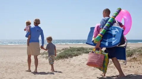 How to save money on planes and accommodation Getty Images Family on beach