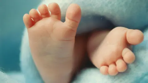 Babies from three people's DNA prevents heriditary disease Getty Images Close up of baby's feet on a blue blanket