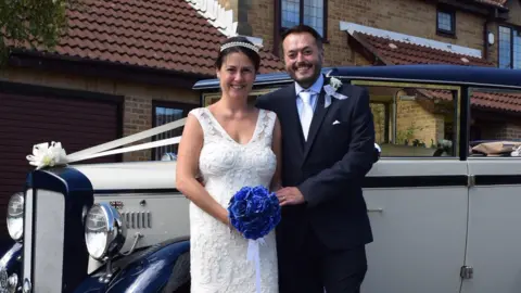 Military aircrew pursuing MoD after cancer diagnoses reaches 180 Anna-Louise Stubbings Anna-Louise and Zach on their wedding day. They are standing in front of a vintage car, Anna is wearing a white sleeveless wedding dress and holding a blue bouquet. Zach is wearing a navy suit. Both are smiling,