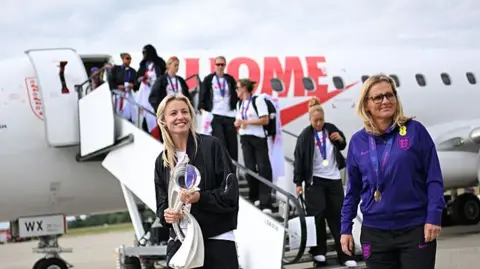 Getty Images Leah Williamson was the first player to emerge from the plane, walking down the stairs of the  gangway alongside head coach Sarina Wiegman.
