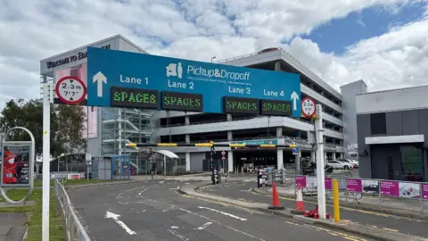 Airport drivers try to beat drop-off charges by parking in laybys A general view of the entrance to the pick-up and drop-off zone at Edinburgh Airport. A blue sign advertising the zone is over the top of the road and states their are four lanes. Underneath each lane marker on the sign is a black screen with green writing featuring the word "spaces".