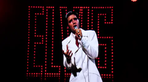 'Atrocious and misleading' show upsets some fans Graham Turner Elvis Presley in a white suit and a microphone in one hand