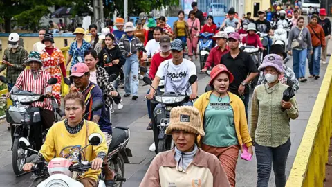 Asia is reeling but is anyone winning? Getty Images Garment workers, men and women, walk out in a large group from their factory during their lunch break in Phnom Penh on July 8, 2025.
