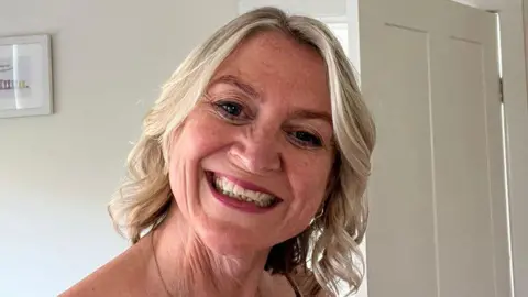 Crying at work - career damaging or just human? Amanda Amanda, who has blonde hair, smiles at the camera with her head tilted slightly to one side