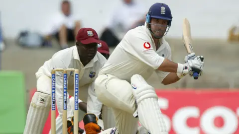Health professionals failed Graham Thorpe, coroner says Getty Images A man wearing all white swinging a cricket bat, while another man wearing gloves stands close by.