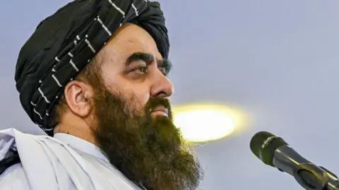 Russia the first to recognise Taliban government in Afghanistan Getty Images Afghanistan's Foreign Minister Amir Khan Muttaqi, with a long black beard, is in profile with a microphone directly in front of him.