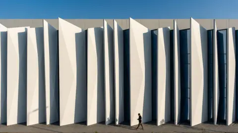 The Gulf bets big on AI as it seeks the 'new oil' Khazna The exterior of a Khazna data centre in Masdar City, Abu Dhabi - it is white and has a "concertina" appearance. The small figure of a man in a suit is walking in front of it.