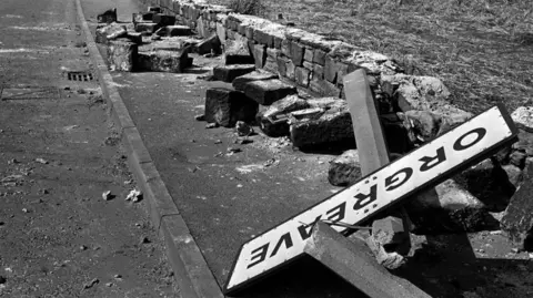 Battle of Orgreave national inquiry confirmed by Yvette Cooper PA Media A black and white image of a twisted sign, felled concrete posts and a broken wall following violence outside the coking plant in Orgreave, South Yorkshire.