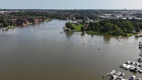 Powerboat driver dies after crash with houseboat at Oulton Broad Shaun Whitmore/BBC A general view of the Oulton Broad marina. Boats and yachts rest in the water.