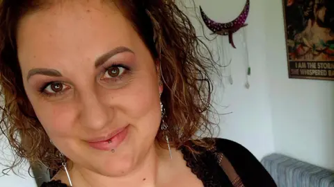 Rents rise by £221 a month in three years, Zoopla analysis suggests Stefania Calhoun with a silver stud lip piercing and long thin silver earrings in a living room, with an ornament and a poster seen hanging on the wall behind her