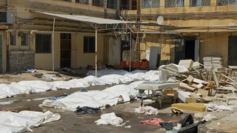 'They shot patients in beds' – BBC hears claims of massacre at Suweida hospital BBC / Jon Donnison White plastic sheets cover bodies in the carpark of a hospital in Suweida. There is debris of chairs and hospital beds scattered across the ground too