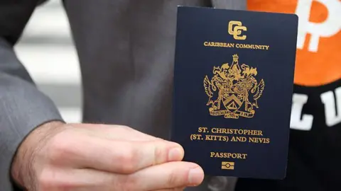 The Caribbean islands that give you a passport if you buy a home Getty Images A man holding a St Kitts passport