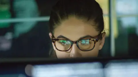 UK borrowing costs fall as investors' nerves ease Getty Images Close of of young woman wearing glasses looking at monitor