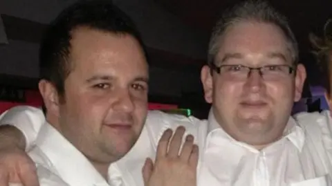 'Fantasist' promised music stars for festival that never happened Adam Purslow Adam Purslow, who is white with short brown hair, stands on the left in a white shirt with James Kenny on the right, with his arm around Adam. James is also wearing a white shirt and has square glasses and greying hair sticking up on end.