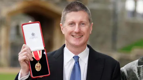 Stats boss quits as minister says new leadership needed Getty Images Sir Robert Chote holds up a medal in a red box