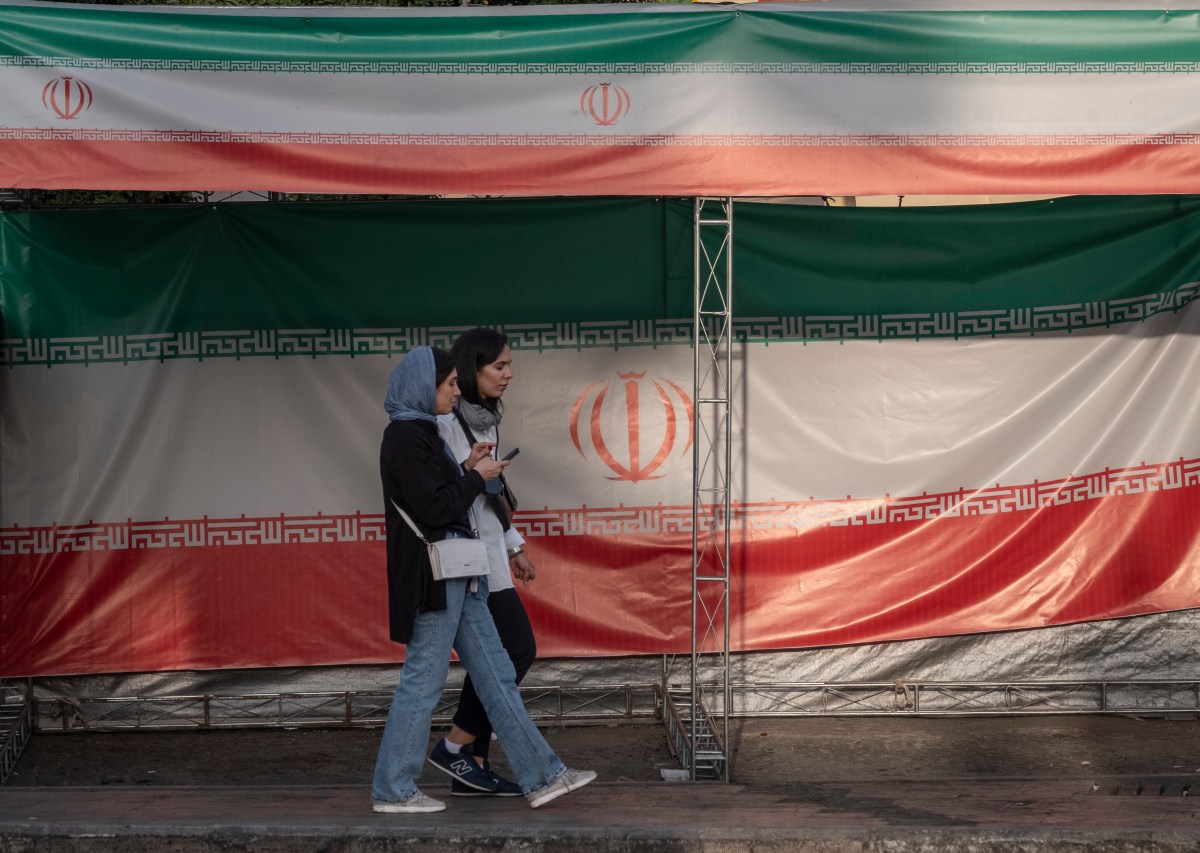 iran flag iranians with phones Apple alerted Iranians to iPhone spyware attacks, say researchers