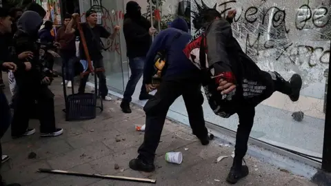 Mexicans protest tourists and gentrification Getty Images Rioters smashing the windows of an upmarket shop in the Roma district of Mexico City