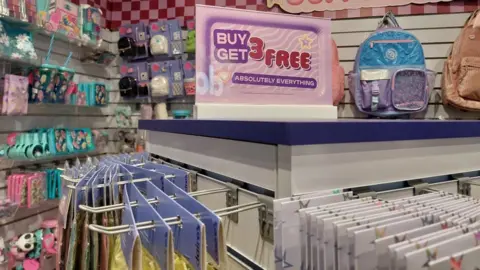 Claire's was glitz 'heaven' for kids before Shein and TikTok came along Grace Dean/BBC Items on sale at a Claire's store, next to a pink sign that says "Buy 3 get 3 free - absolutely everything"