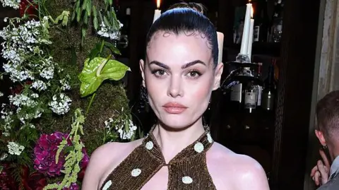 Is super skinny back? UK sees rise in complaints over thin models Getty Images Model Charli Howard poses in a gold sparkly dress with white polka dots and her brown hair slicked back into a bun