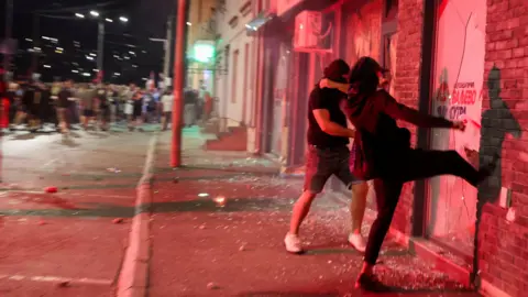 Serbia ruling party offices set on fire in fifth night of protests Reuters Anti-government protesters break the windows of the offices of the ruling Serbian Progressive Party