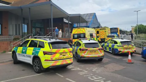 BBC Police cars and ambulance vehicles are outside Queen Elizabeth Queen Mother Hospital in Margate.