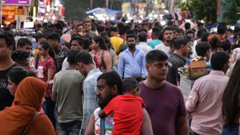 How to get AI to work in its 22 languages Getty Images A man holding a child speaks to a woman amid a large crowd in Kolkata, India.