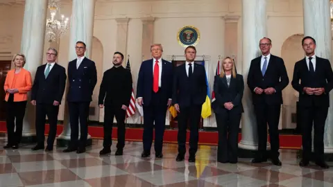 Starmer hails breakthrough on Ukraine PA Media All the leaders standing in line for a photo ahead of the meeting. They are in the White House
