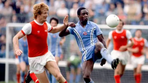 Coventry City Football Club purchases CBS Arena Getty Images Two men are playing football and wearing football kits while standing on a football pitch.