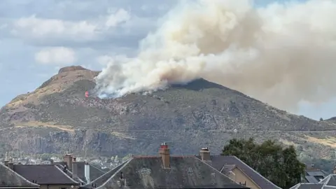 Karen Clough a fire spreads across a hill emitting lots of grey smoke 
