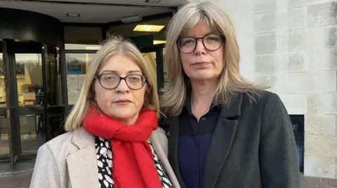 Ammanford stabbing report finds girl was fascinated by weapons and war Two women, both with short blonde hair and wearing glasses, looking at the camera. Fiona, on the left, is wearing a red scarf, off-white jacket and black and white blouse; on the right, Liz is wearing a grey jacket and blue and black shirt. They are stood in front of the doors of a court building.