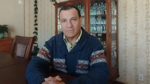 Economic woes dominate as Bolivia prepares to go to the polls Bolivian political scientist and analyst Franklin Pareja sitting at his home