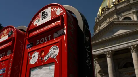Denmark's state postal service calls time on letter deliveries BBC Red post boxes on a street in Copenhagen