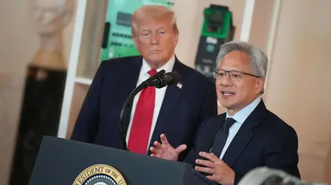 Why the US is taking a cut from China sales Getty Images US President Donald Trump (L) listens as Nvidia CEO Jensen Huang speaks in the Cross Hall of the White House during an event on "Investing in America"