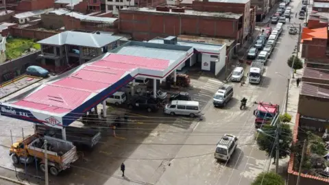 Economic woes dominate as Bolivia prepares to go to the polls Getty Images Cars and cans queuing to get into a petrol station in Bolivia