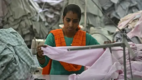 PM Modi says make and spend in India as 50% tariffs kick in AFP via Getty Images A garment worker wearing a green dress and saffron scarf sorts tailored shirts at an apparel manufacturing unit in Bengaluru on August 25, 2025.